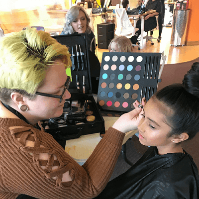 Schuyler working on clien (1) student applying makeup on client